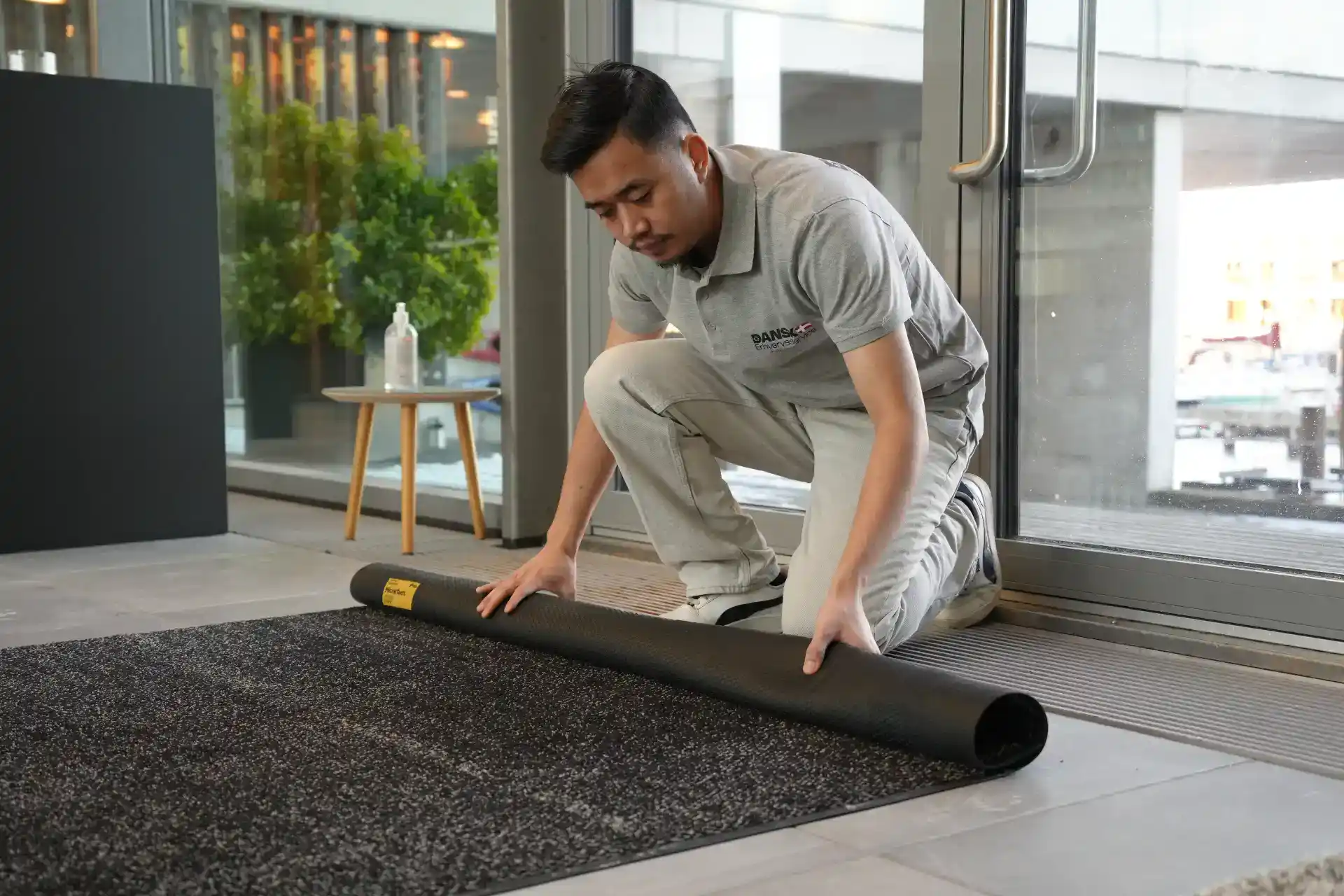 Mand lægger gulvbelægning i et erhvervsområde.